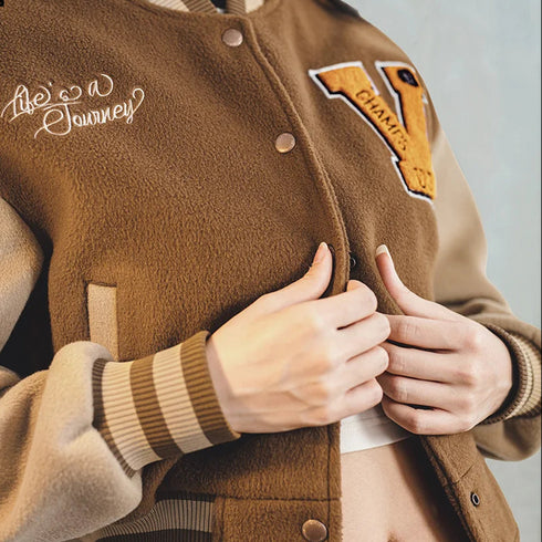 Brown varsity jacket with embroidered text and patches, featuring the brand 'Maden Clothing'.